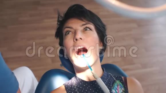 一个坐在牙科椅上的女孩转动眼睛的肖像视频的预览图