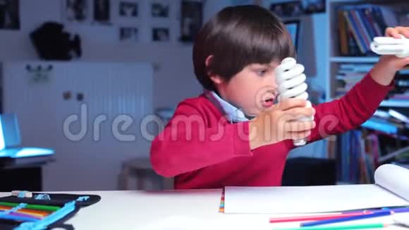学校课桌上的一个男孩在玩荧光灯视频的预览图