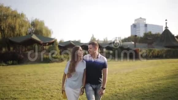 幸福夫妇在公园散步微笑和交谈的正面景色视频的预览图