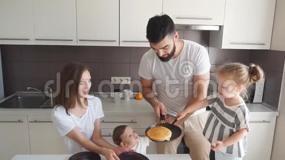 一对笑容可掬的夫妇和他们的孩子一起炼出美味的蛋糕视频的预览图
