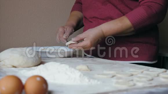 成熟的女性手在家厨房用奶酪包饺子视频的预览图