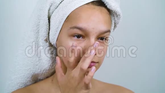 头上戴浴巾的少女在检查她的脸视频的预览图