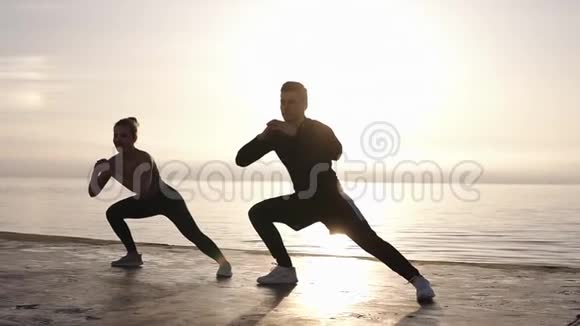 年轻的白种人运动员和他的女伴在每天早晨慢跑之前伸展双腿视频的预览图