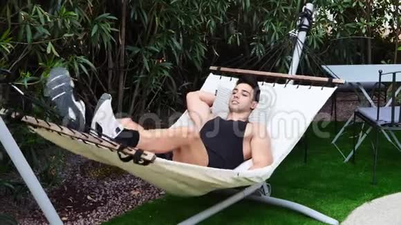 年轻人在花园的吊床上放松视频的预览图