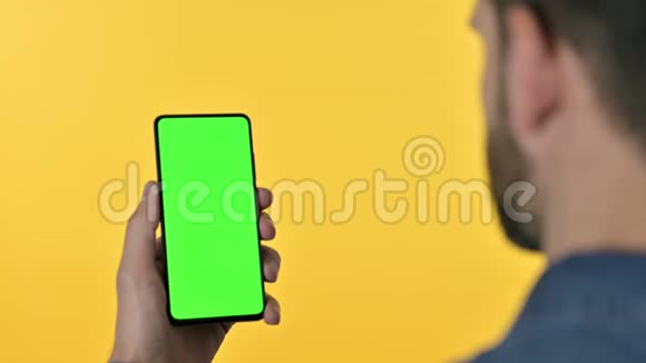 设计人员看带有彩色屏幕黄色背景的智能手机视频的预览图