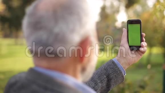 把老人用电话锁在外面绿色屏幕背面的人持有电话在伤害的长度爷爷视频的预览图
