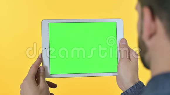 带有彩色屏幕黄色背景的平板上的人滚动视频的预览图