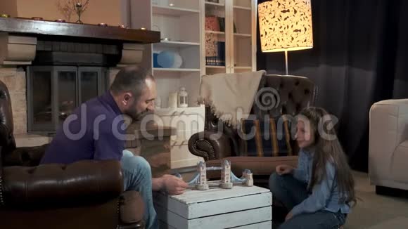 父亲和女儿在客厅的壁炉附近度过闲暇时光视频的预览图