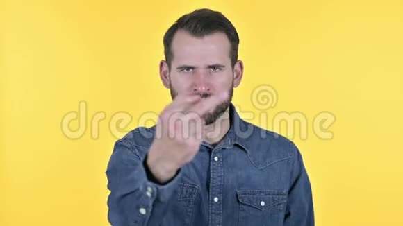 愤怒的胡子青年男子中指黄色背景视频的预览图