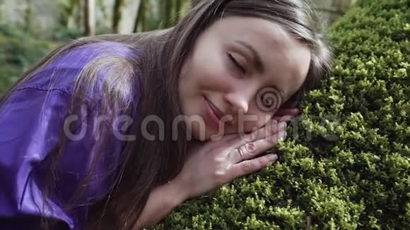 女孩在森林里长满苔藓的大树干上熟睡然后迅速地走了出去视频的预览图
