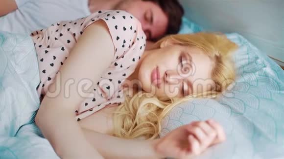 年轻情侣早上醒来女人看着镜头视频的预览图