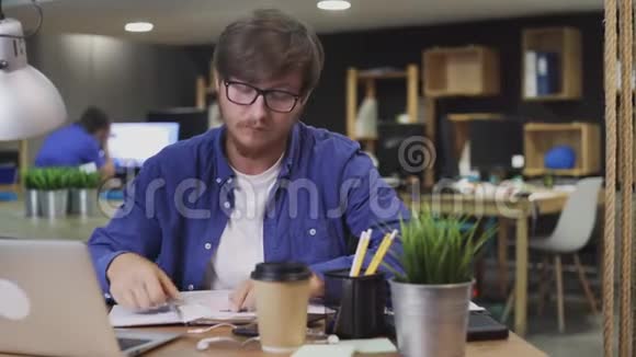 年轻人用钢笔在粘的五彩贴纸上写纸条视频的预览图