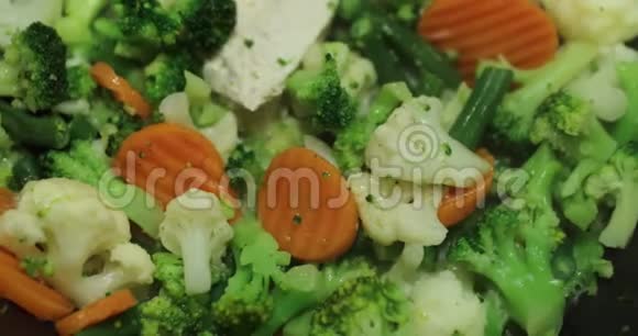 烹饪一种新鲜的切菜在煎锅上煎胡萝卜花椰菜西兰花哈里克打开盖子视频的预览图