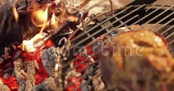 腌肉的大块放在一个圆形的烤架上靠近裸露的大火焰肉用芥末红煤腌制视频的预览图