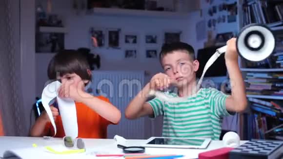 两个男孩正坐在桌子旁上上学校课视频的预览图