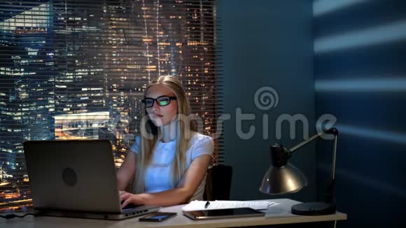 美丽的女程序员晚上在现代办公室工作视频的预览图