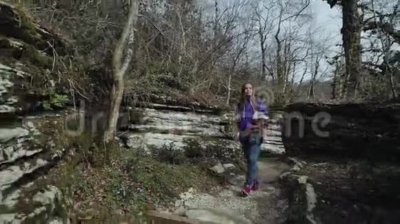 阳光明媚的一天美丽快乐的女孩走在山缝里视频的预览图