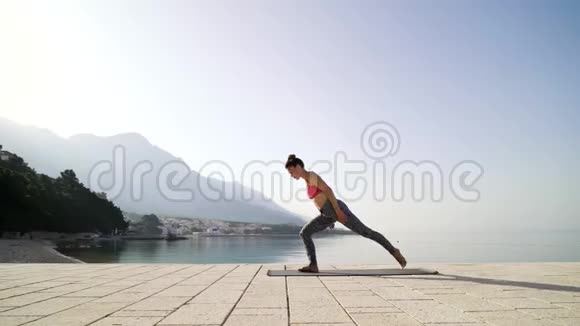 运动女性在海滨木板路上练习瑜伽提供免费和复印空间视频的预览图