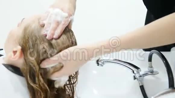 美容工作室用洗发水化妆和美容院洗头把发型师洗头发的手收起来视频的预览图