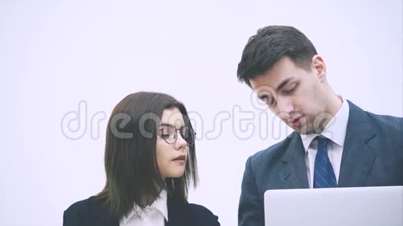 帅哥拿着一台笔记本电脑向她的搭档解释一些事情视频的预览图