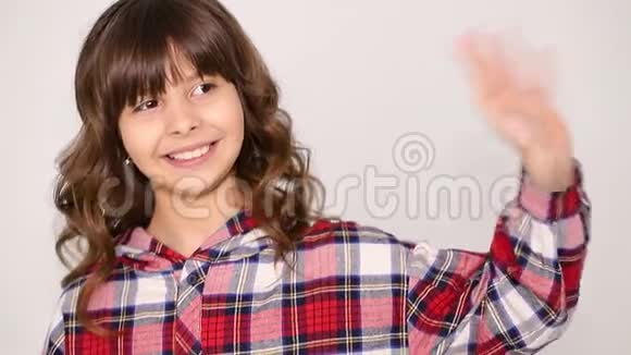 一个十几岁的女孩在网上和朋友聊天挥舞着她的手视频的预览图