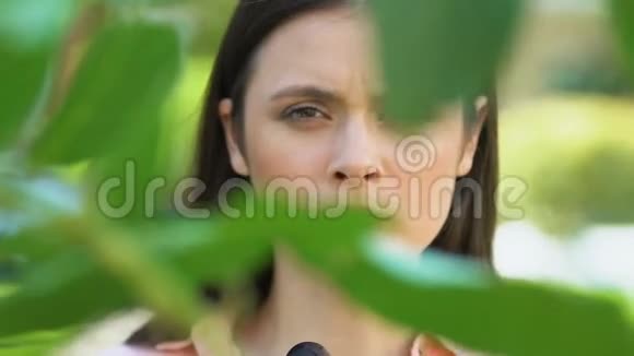 一位年轻女子用望远镜看着站在树间的人们视频的预览图