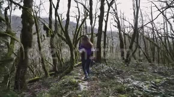 美女走在童话森林里跳过倒下的树视频的预览图