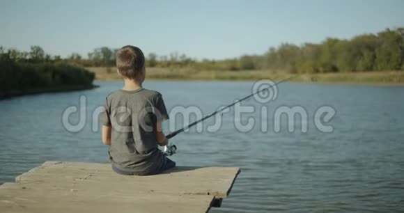 一个拿着鱼竿的小男孩捕鱼的概念视频的预览图