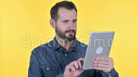 胡子青年在桌上做视频聊天黄色背景视频的预览图