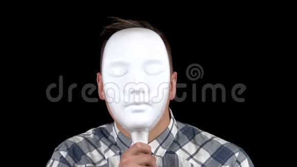 一个年轻人摘下面具脸上流露出情感穿衬衫的愤怒男人一个人把脸藏在白色的后面视频的预览图
