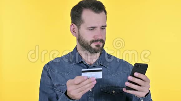 智能手机在线支付的胡子青年男子黄色背景视频的预览图
