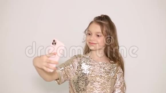 一个年轻女孩站在智能手机相机前笑的肖像视频的预览图