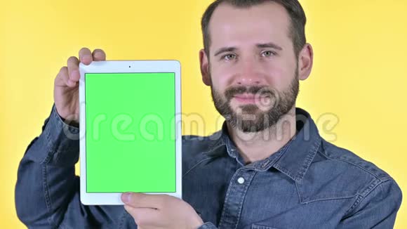 男性设计师展示带有彩色屏幕的平板屏幕黄色背景视频的预览图