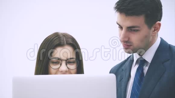 漂亮的女商人在笔记本电脑里给她的搭档看东西他点头微笑表示满意视频的预览图