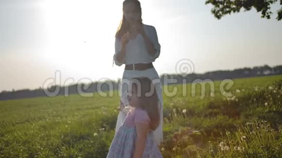 妈妈穿着白色衣服给她的小女儿吹肥皂泡视频的预览图