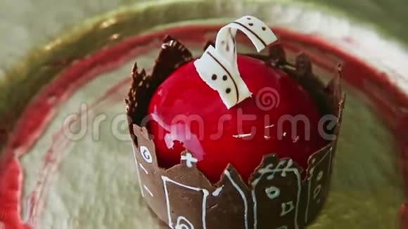 在金色盘子上旋转着红色釉面和巧克力城堡的现代甜点视频的预览图