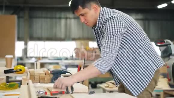 男性木工用特殊仪器将木材固定在工作台上视频的预览图