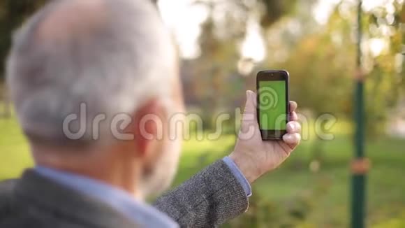把老人用电话锁在外面绿色屏幕背面的人持有电话在伤害的长度爷爷视频的预览图
