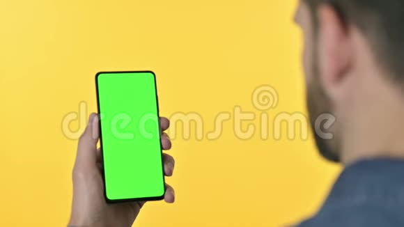 使用带有彩色屏幕的智能手机的人黄色背景视频的预览图