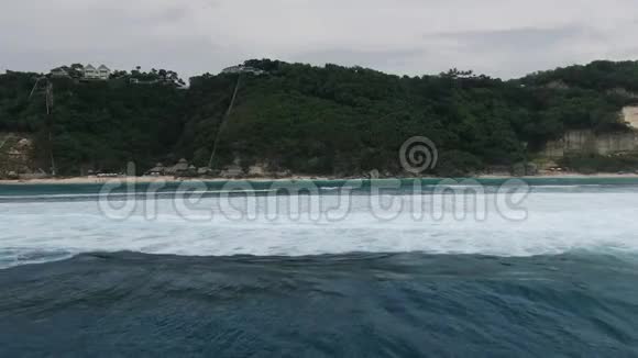 一架无人机飞过印度尼西亚巴厘岛海滨的一个小村庄视频的预览图