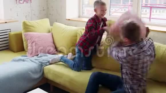 快乐的父子在沙发上玩枕头大战视频的预览图