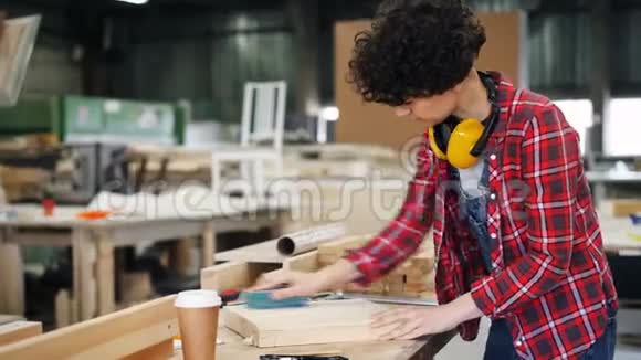 年轻女士工厂工人用磨块抛光木材工作间视频的预览图