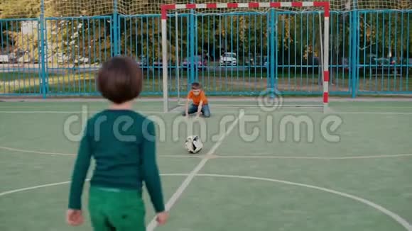 两个学童在学校操场上踢足球视频的预览图