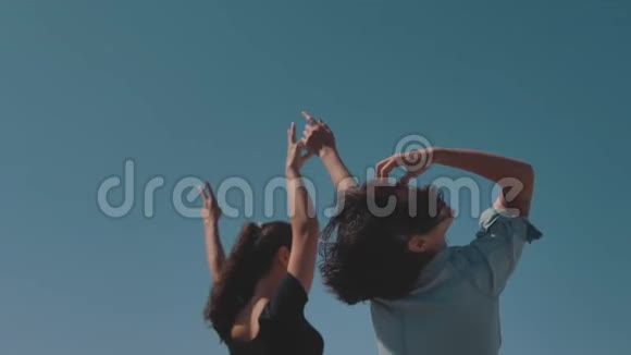两个女孩举起双手在天空的背景上自由和生活方式的概念拍摄红色4k10位颜色视频的预览图