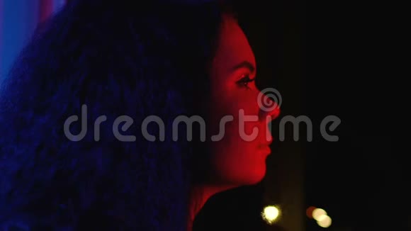 年轻的微笑女人看着夜晚的城市灯光享受家庭聚会放松视频的预览图