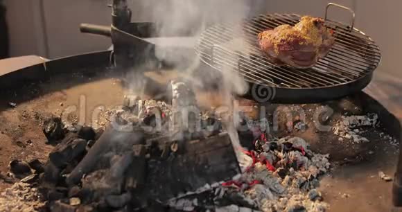 腌肉的大块放在一个圆形的烤架上靠近裸露的大火焰肉用芥末红煤腌制视频的预览图