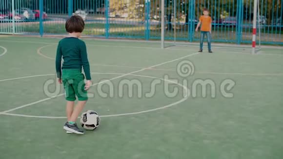 一个小学生在球门上踢足球另一个小学生接住球视频的预览图