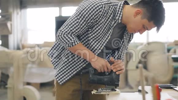 一个人在车间里锯木一个人做家具视频的预览图
