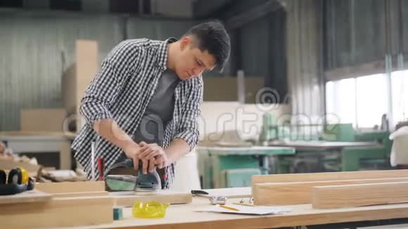 有吸引力的木工用砂光机在工作室打磨木材视频的预览图