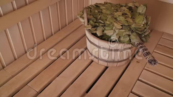 木制桑拿浴室中的各种桑拿配件带有扫帚的桑拿浴室的内部视频的预览图
